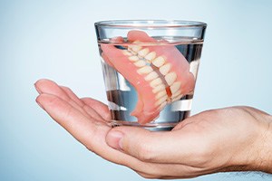 a glass of water with dentures inside